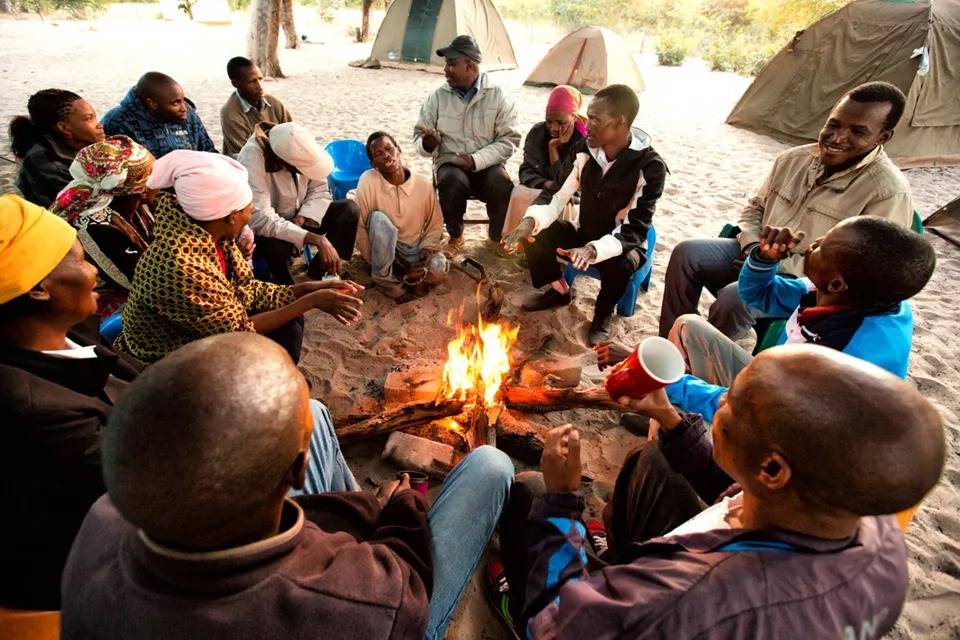 San people sit around a campfire