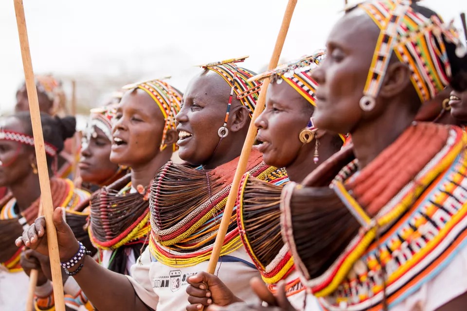 Rendille women in traditional dress celebrate, sing, and dance