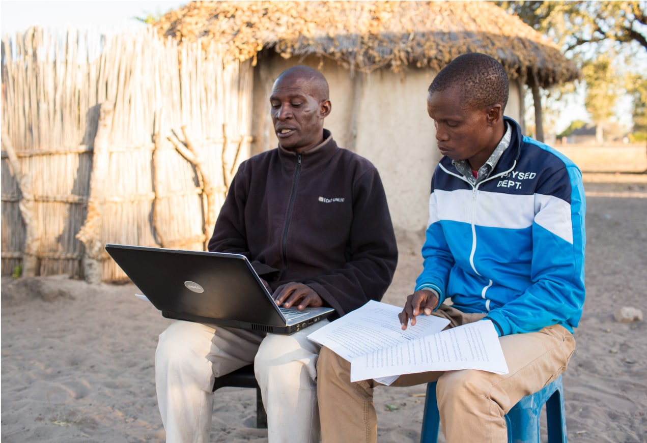 Team members in Africa check a Scripture translation on their laptops.