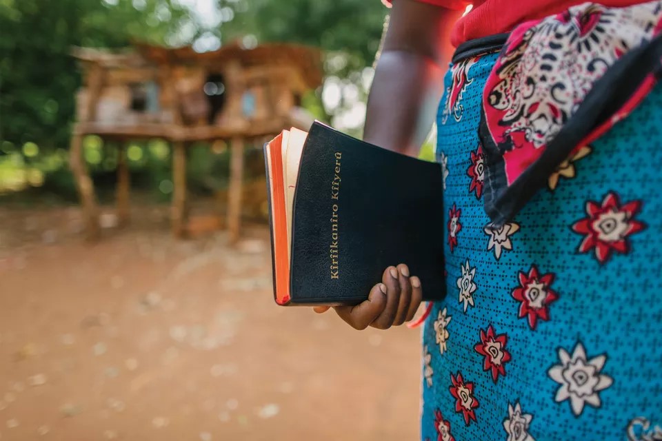 Woman holding Tharaka Bible