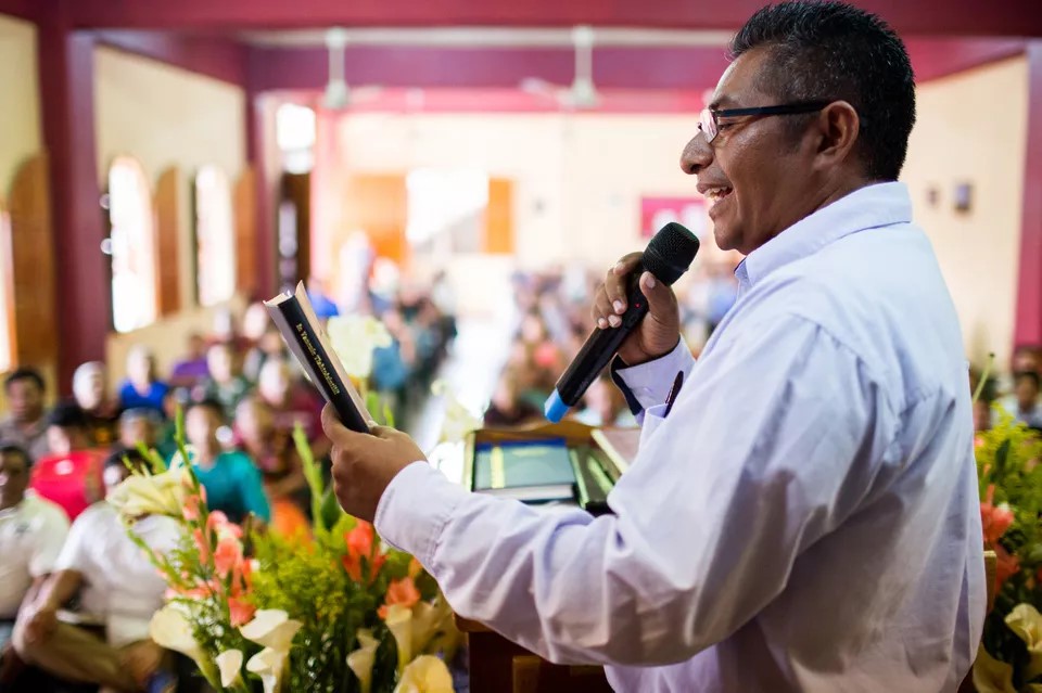 Mexican man preaching to his congregation using Zapotec Scripture