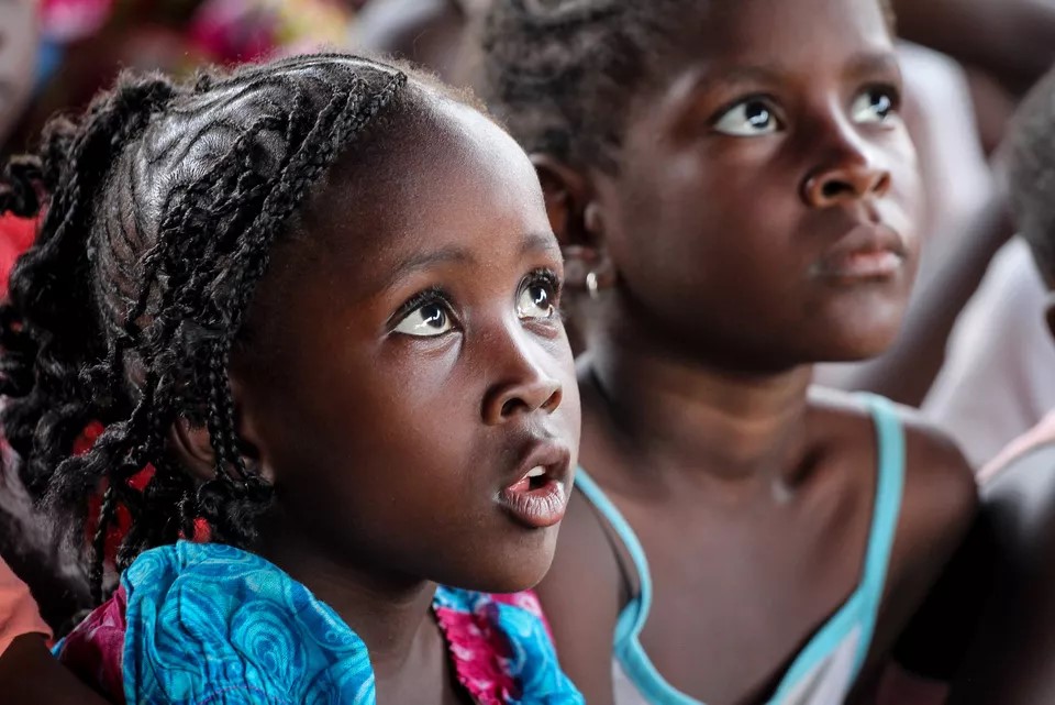 Wide-eyed African children watching a movie