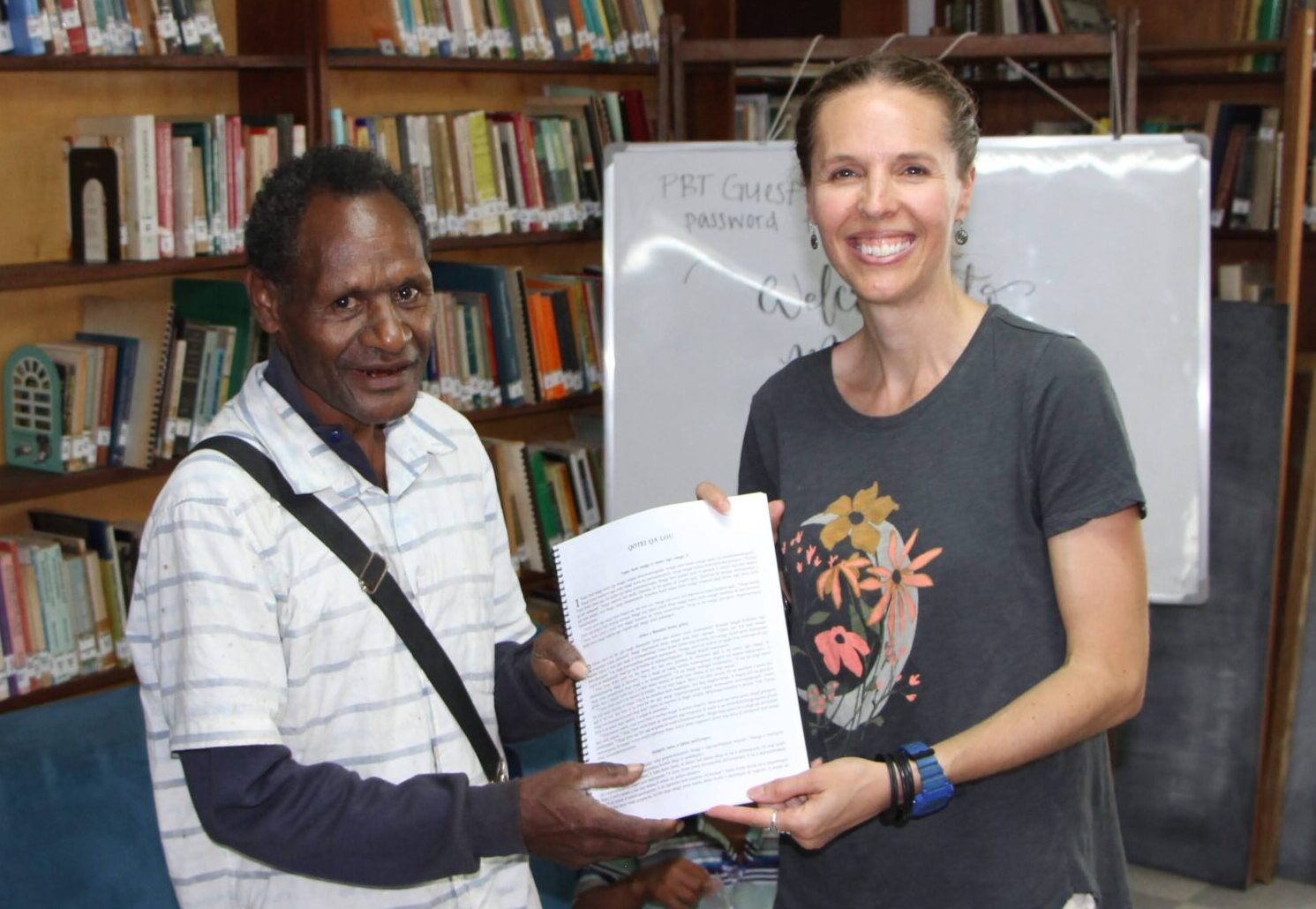 American woman and man in Papua New Guinea hold Bible