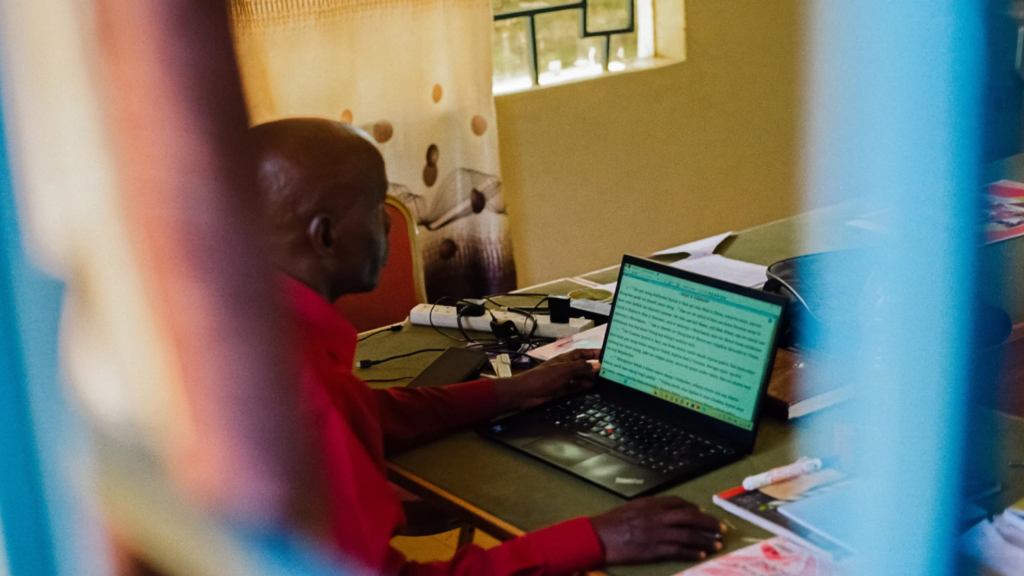 Man sitting at laptop reading off the screen