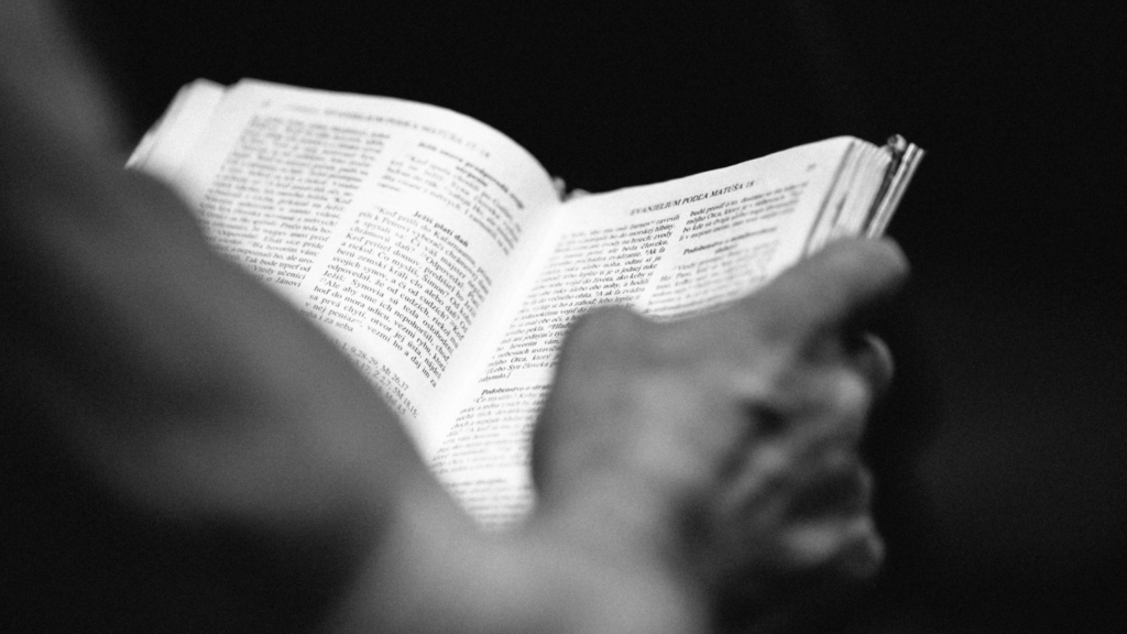 black and white photo of hands holding a Bible