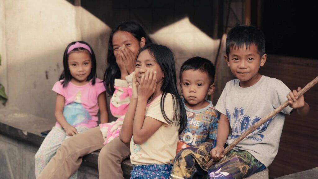 three little girls and two boys smiling