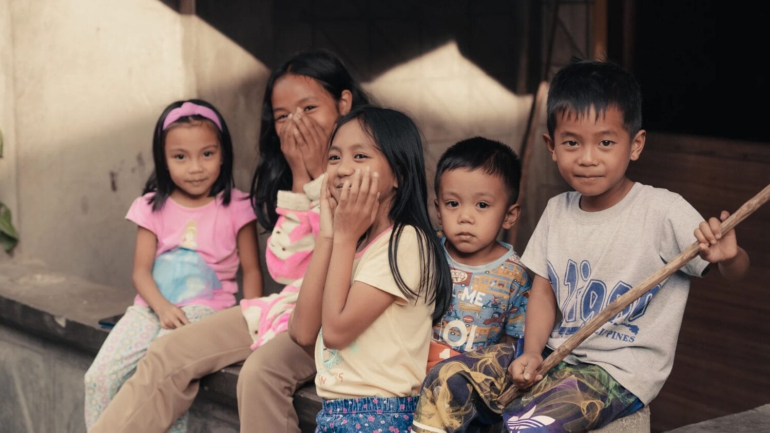 three little girls and two boys smiling